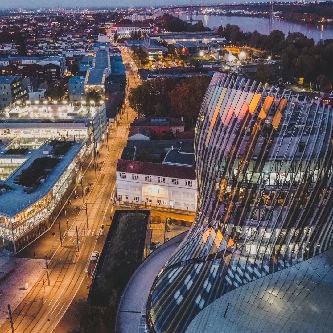 Vue nocturne de la Cité du Vin à Bordeaux, un lieu emblématique desservi par Taxi Télé pour tous vos trajets.